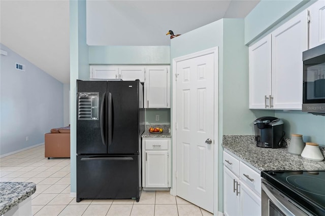 kitchen with black refrigerator, white cabinetry, and light stone countertops