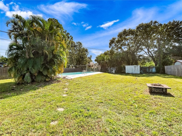 view of yard with a fenced in pool and an outdoor fire pit