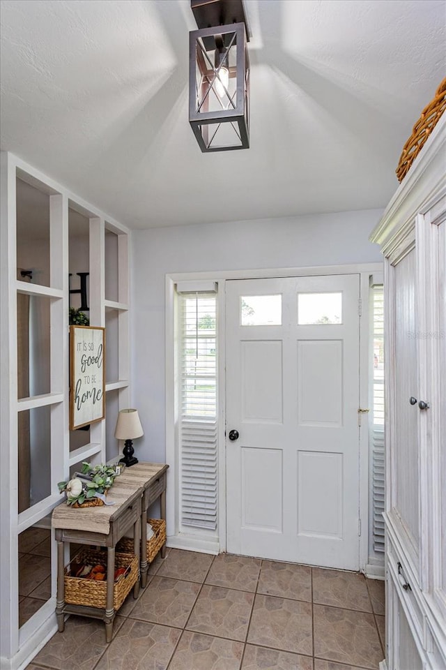 tiled entryway featuring a textured ceiling