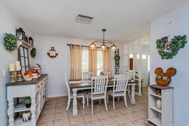 tiled dining area with an inviting chandelier