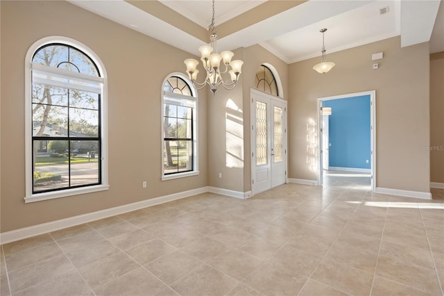 empty room featuring ornamental molding, light tile patterned floors, and an inviting chandelier