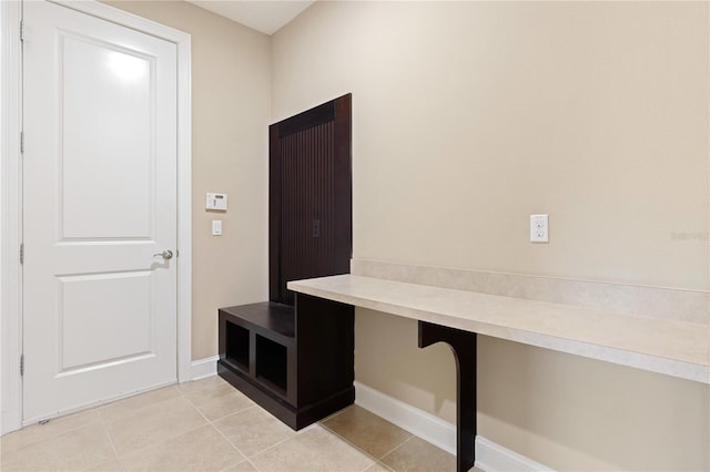 mudroom featuring built in desk and light tile patterned floors