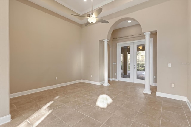 tiled empty room featuring french doors, ornate columns, ceiling fan, and ornamental molding