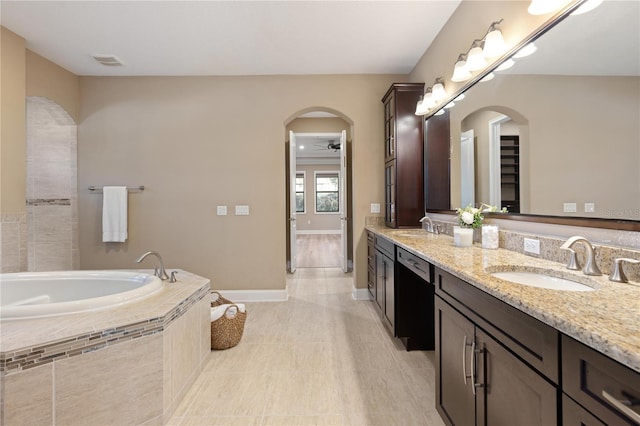 bathroom featuring wood-type flooring, vanity, tiled bath, and ceiling fan