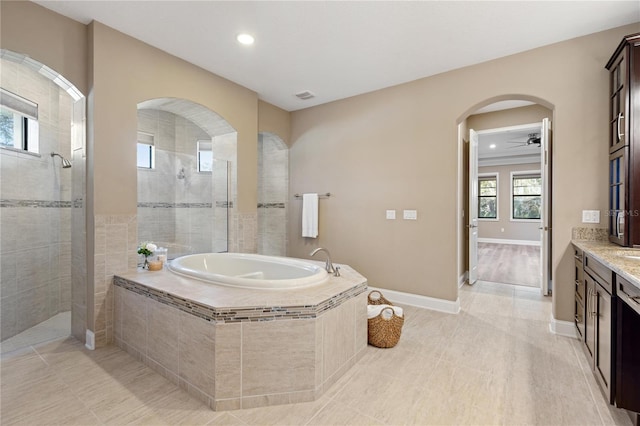 bathroom with plenty of natural light, ceiling fan, shower with separate bathtub, and vanity