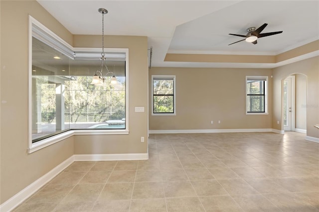 spare room with a healthy amount of sunlight, ceiling fan with notable chandelier, and ornamental molding