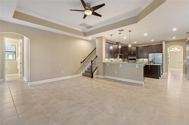 kitchen featuring dark brown cabinetry, kitchen peninsula, crown molding, pendant lighting, and appliances with stainless steel finishes