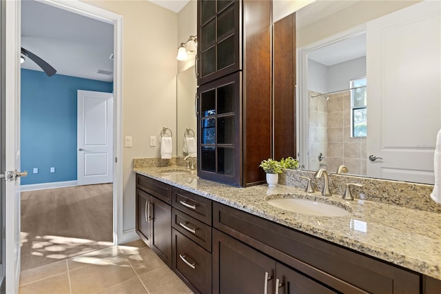 bathroom featuring tile patterned flooring, vanity, and a shower