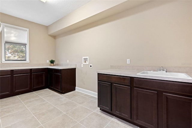 laundry room with cabinets, hookup for a washing machine, electric dryer hookup, sink, and light tile patterned floors