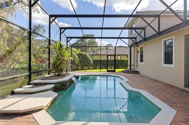 view of swimming pool with glass enclosure, pool water feature, and a patio