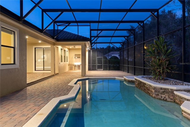 view of pool with a patio area and glass enclosure