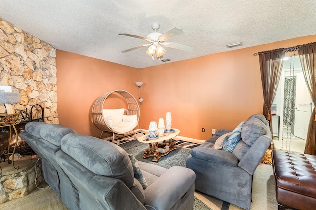 carpeted living room with ceiling fan and a textured ceiling