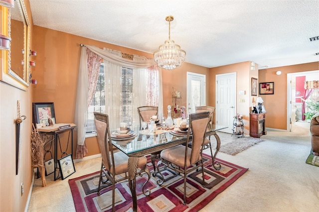 dining room featuring light carpet, plenty of natural light, and a textured ceiling