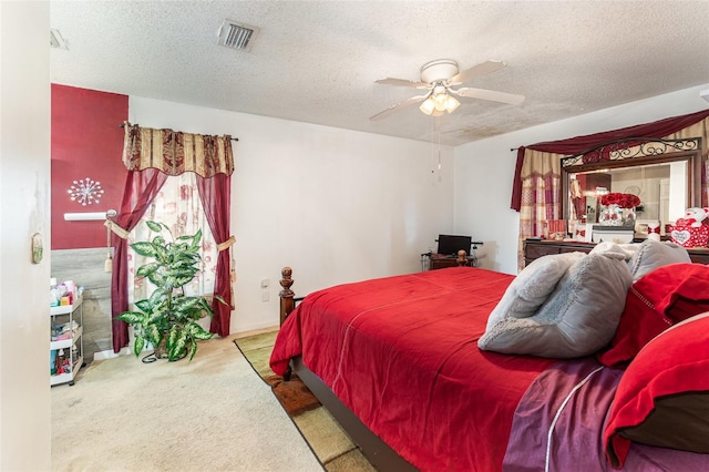 carpeted bedroom featuring a textured ceiling and ceiling fan