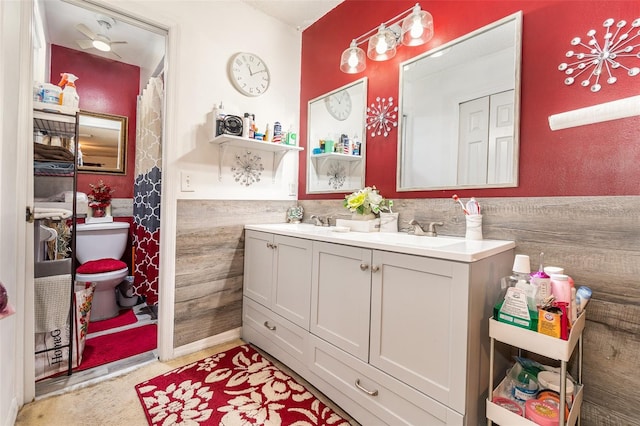 bathroom featuring vanity, tile walls, and toilet