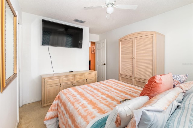 bedroom with light carpet, a textured ceiling, a closet, and ceiling fan