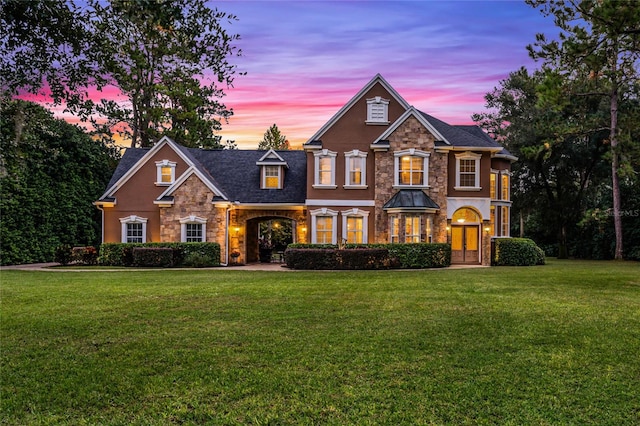 view of front of home with a yard and stone siding