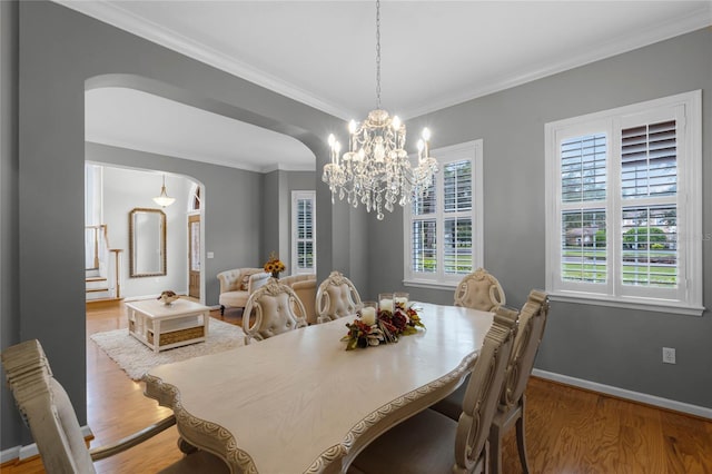 dining room with light wood-type flooring and crown molding