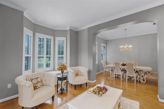 living room featuring ornamental molding, light wood-type flooring, and a notable chandelier