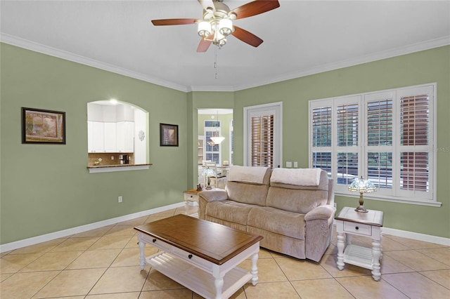 living room featuring light tile patterned floors, ceiling fan, and crown molding