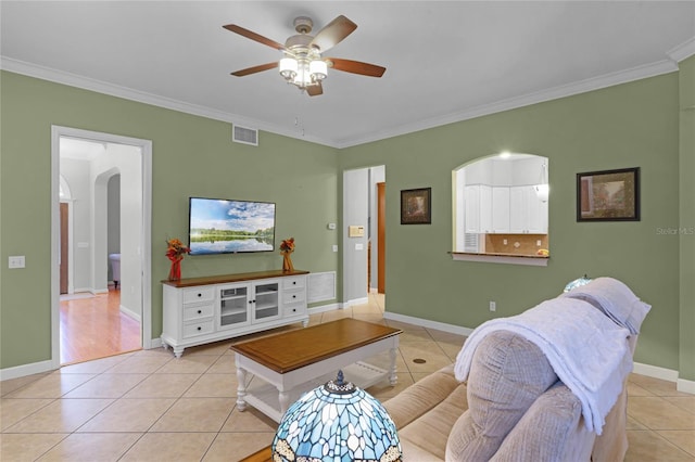 tiled living room with ceiling fan and ornamental molding