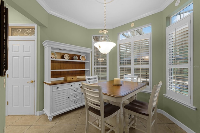 dining space with light tile patterned flooring and ornamental molding