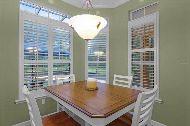 dining room with a wealth of natural light, wood-type flooring, and crown molding