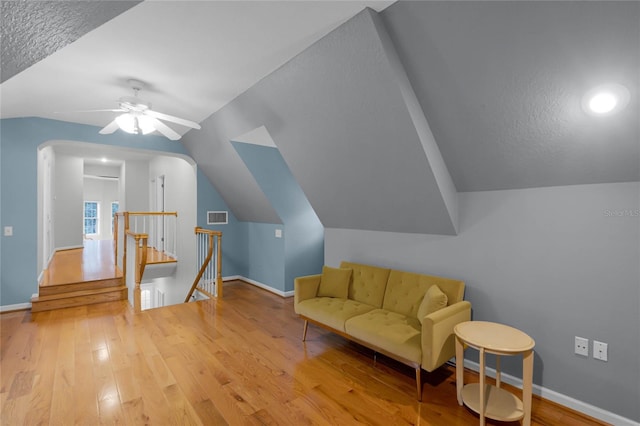 sitting room with vaulted ceiling, hardwood / wood-style flooring, ceiling fan, and a textured ceiling