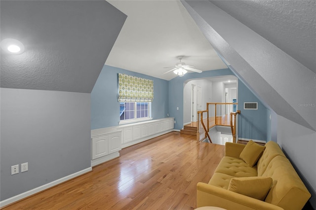 additional living space with light hardwood / wood-style floors, a textured ceiling, and lofted ceiling