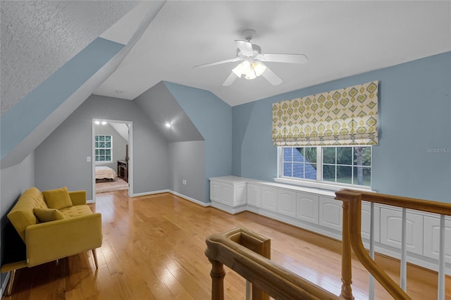 bonus room with ceiling fan, a textured ceiling, light hardwood / wood-style flooring, and vaulted ceiling