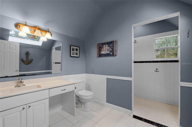 bathroom featuring tiled shower, toilet, tile patterned floors, vaulted ceiling, and vanity