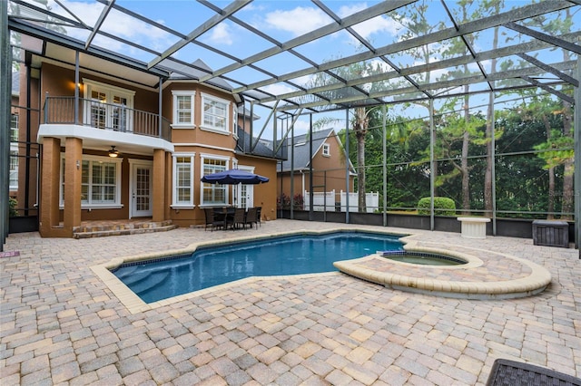 view of pool with an in ground hot tub, ceiling fan, glass enclosure, and a patio area