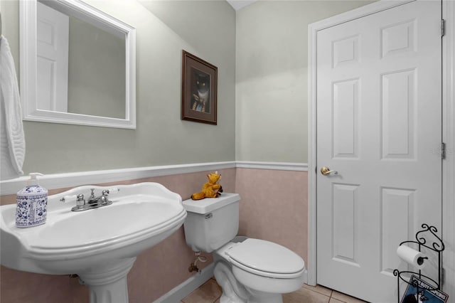 half bath with toilet and tile patterned flooring