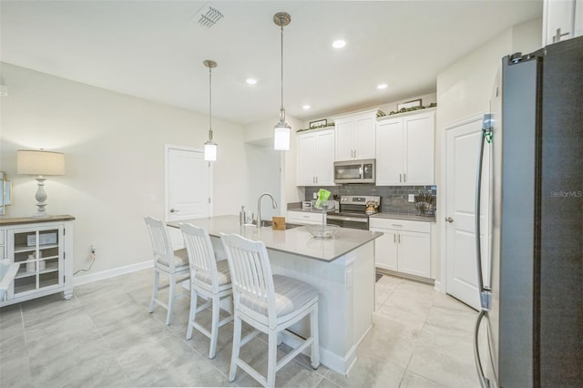 kitchen with white cabinetry, pendant lighting, a kitchen island with sink, and stainless steel appliances