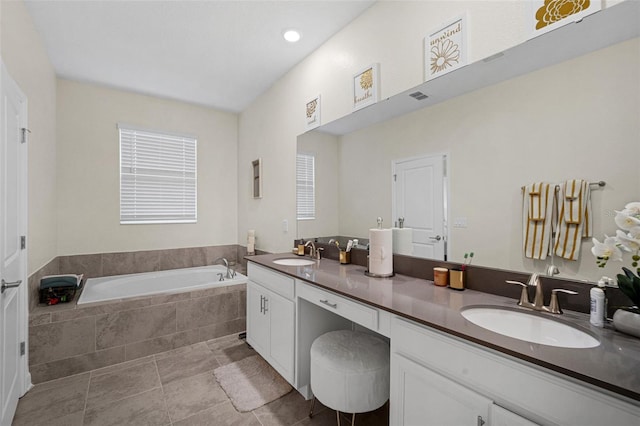 bathroom with vanity and tiled tub