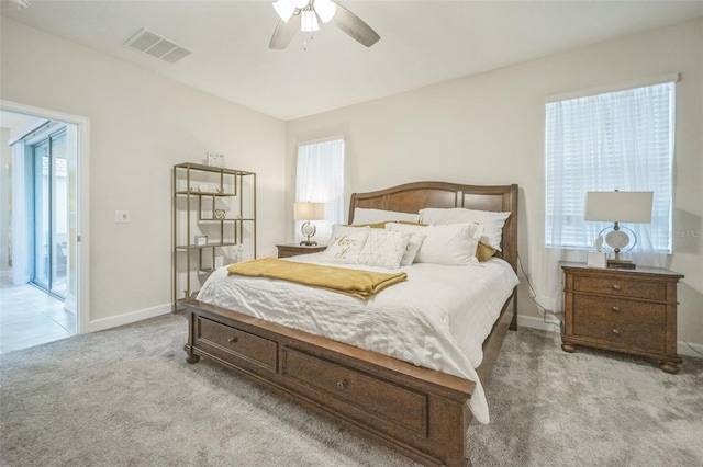 bedroom featuring multiple windows, light carpet, and ceiling fan