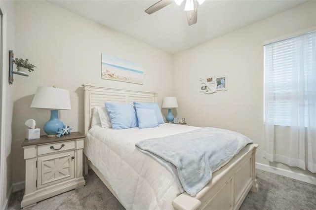 bedroom with ceiling fan and dark colored carpet