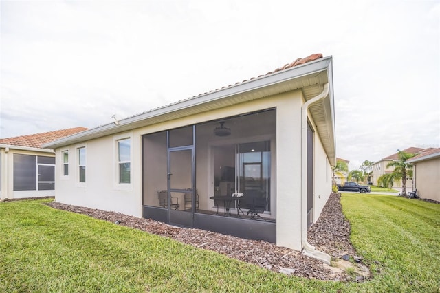 rear view of property with a sunroom and a yard