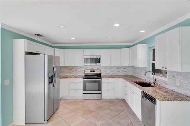 kitchen with appliances with stainless steel finishes, backsplash, sink, stone counters, and white cabinets