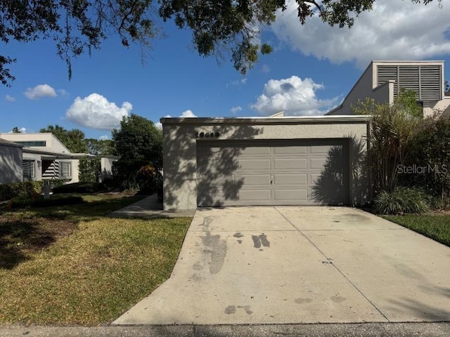 13619 Twin Lakes Ln Unit 15, Tampa, FL 33618 - view of home's exterior featuring a yard, concrete driveway, an attached garage, and stucco siding