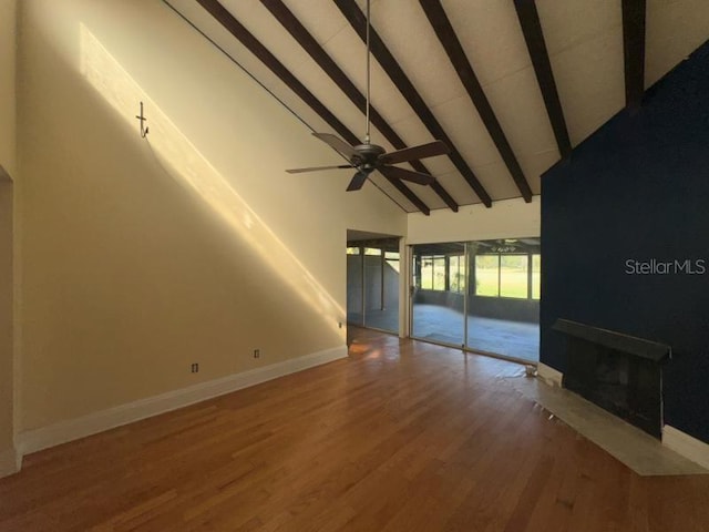 unfurnished living room with hardwood / wood-style floors, ceiling fan, high vaulted ceiling, and beam ceiling