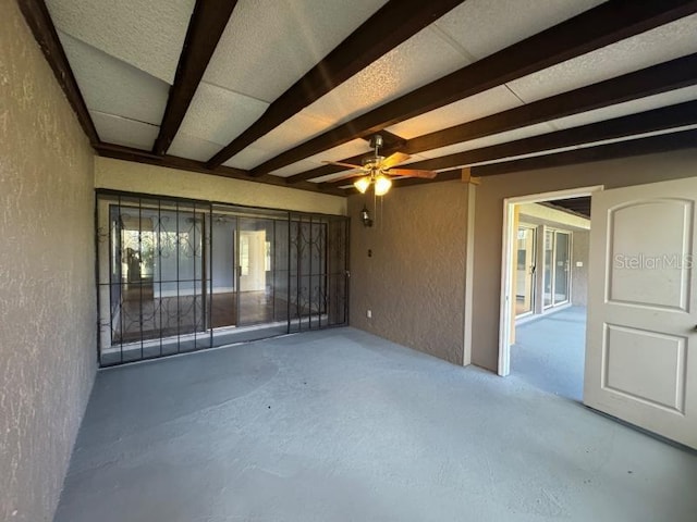 13619 Twin Lakes Ln Unit 15, Tampa, FL 33618 - spare room featuring a textured wall, beamed ceiling, ceiling fan, and concrete floors