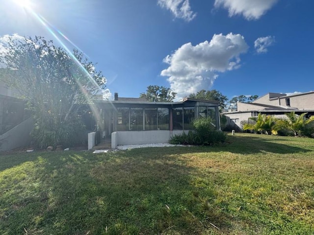 13619 Twin Lakes Ln Unit 15, Tampa, FL 33618 - back of house featuring a sunroom and a lawn
