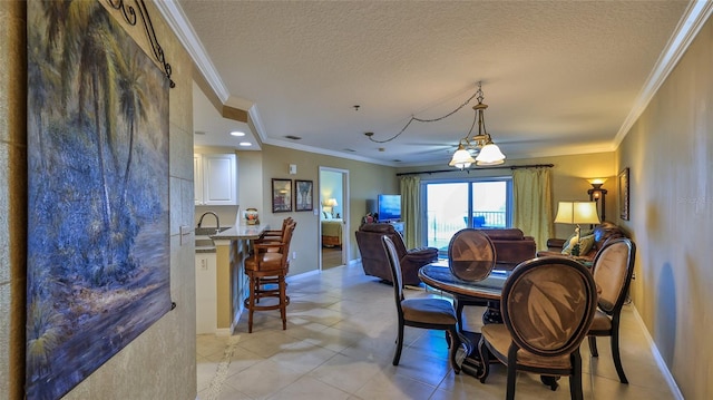 tiled dining area with an inviting chandelier, sink, a textured ceiling, and ornamental molding