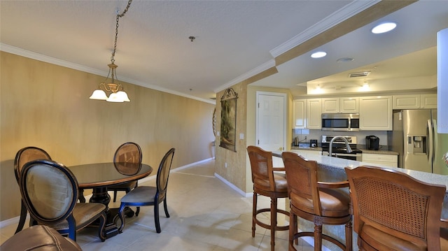 kitchen featuring crown molding, white cabinetry, appliances with stainless steel finishes, hanging light fixtures, and a chandelier