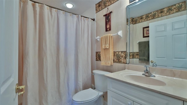 bathroom featuring vanity, curtained shower, a textured ceiling, and toilet