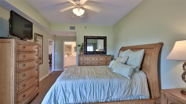 bedroom with hardwood / wood-style floors, ceiling fan, and connected bathroom