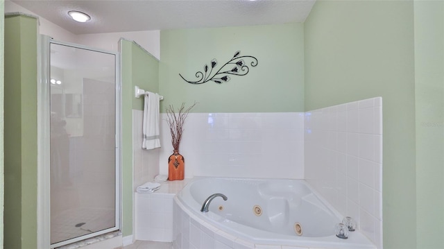 bathroom featuring a textured ceiling and independent shower and bath