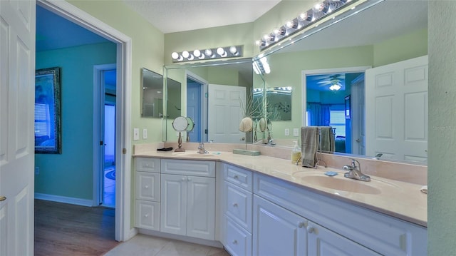 bathroom featuring vanity, wood-type flooring, ceiling fan, and a textured ceiling