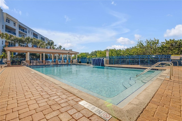 view of swimming pool with pool water feature and a patio area